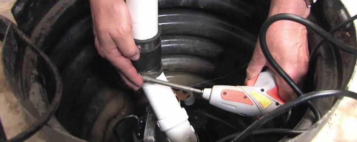 Sump pump installation technician connecting PVC discharge piping in Denver, CO